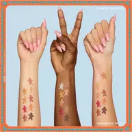 Features three arms with diverse skin tones, each displaying swatches of the eyeshadows from the NYX Professional Makeup Holiday Gingerbaddie Palette, illustrating how the colors appear on different complexions.